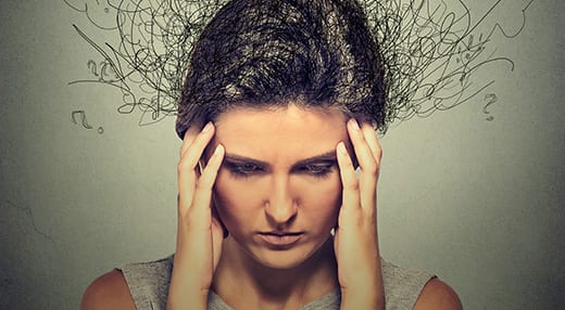 mulher com as mãos na cabeça tentando entender como controlar a ansiedade
