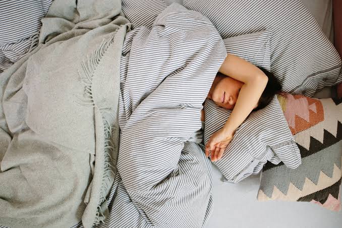 homem deitado na cama com síndrome de burnout