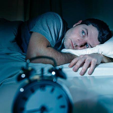 homem na cama pensando o que fazer ao Acordar de Madrugada e Não Dormir Mais